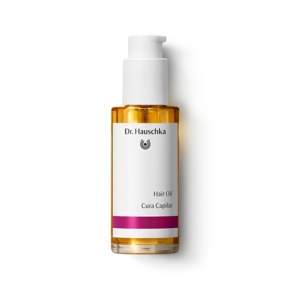 Bottle of Dr. Hauschka Hair Oil with white pump top on a plain white background., hair oil, cura capilar, orange bottle, pump bottle, dr. hauschka