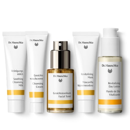 Five Dr. Hauschka skincare products in a neat row on a white background, including cleansing milk, cream, toner, mask and day lotion.