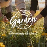 Hands picking flowers in a sunny field with overlaid text: 'The Giving Garden' and 'Blooming Rewards'.