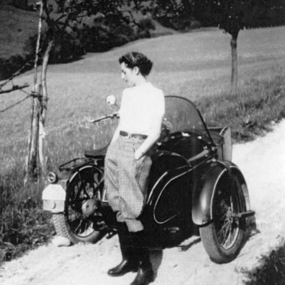 Elisabeth Sigmund standing next to old fashioned motorcycle.