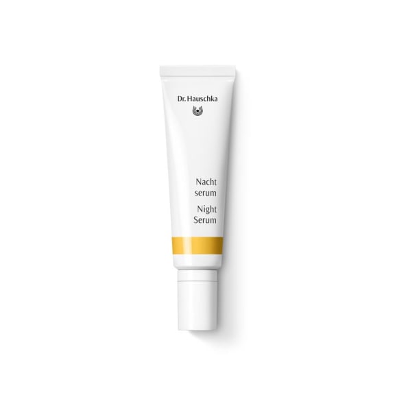White Dr. Hauschka Night Serum tube with an orange band, shown upright on a plain white background.