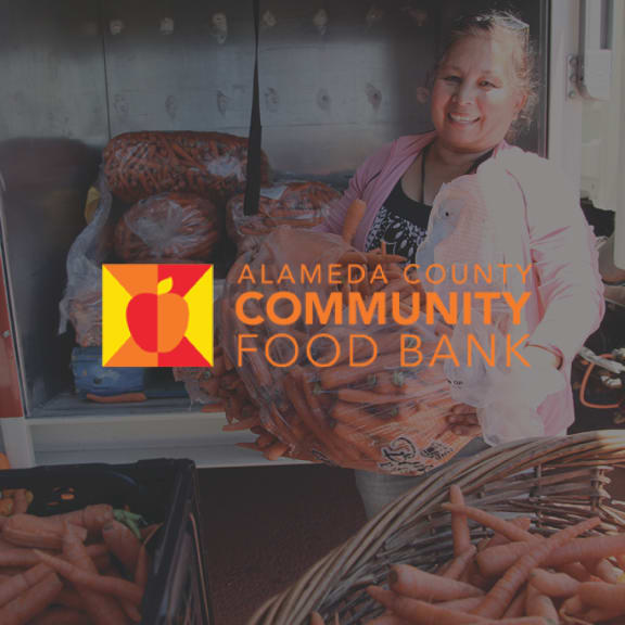 Alameda County Community Food Bank logo over a volunteer holding bags of carrots beside a food truck.