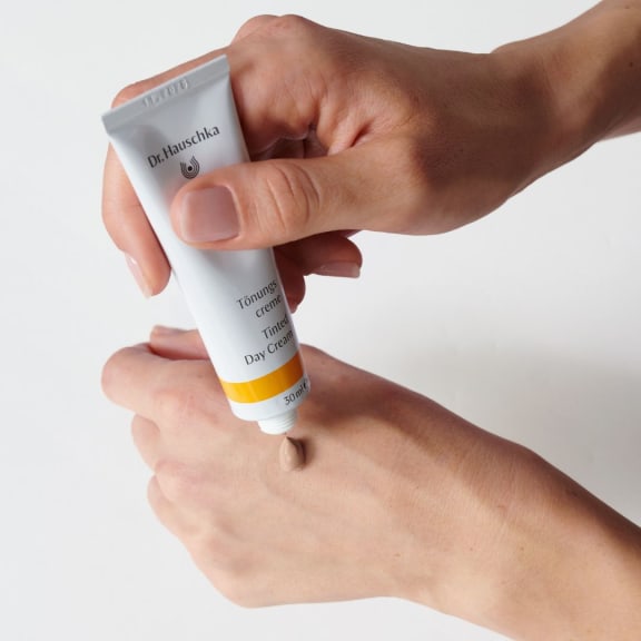 tinted day cream application on hand