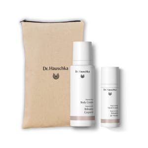 Dr. Hauschka gift set with beige pouch, body cream and hand cream bottles on a white background.