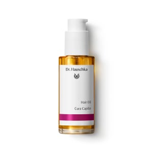 Bottle of Dr. Hauschka Hair Oil with white pump top on a plain white background., hair oil, cura capilar, orange bottle, pump bottle, dr. hauschka