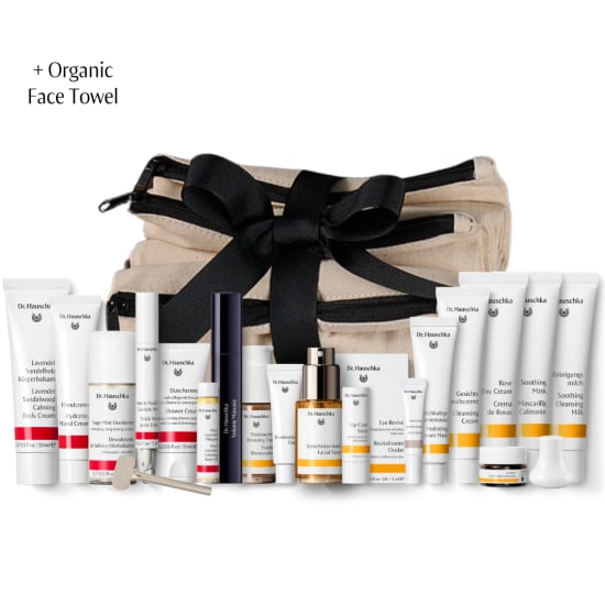Dr. Hauschka gift set with organic face towel, tied with black ribbon and surrounded by skincare products.