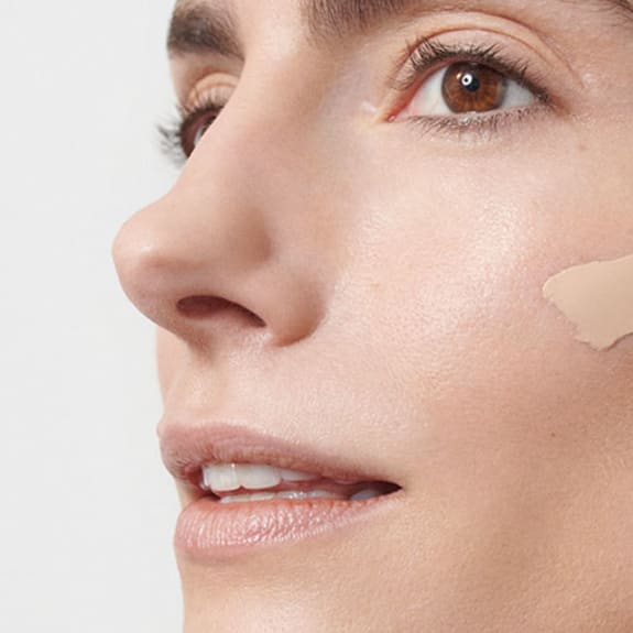 Model applying makeup for dry skin