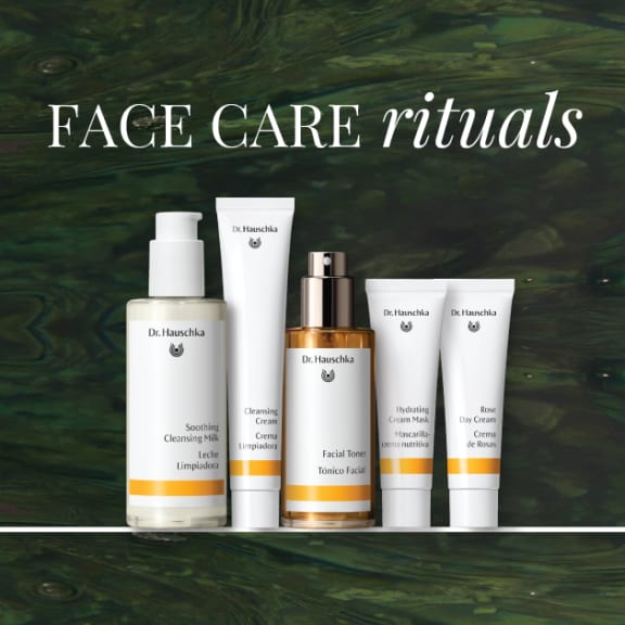 Dr. Hauschka face care rituals ad with five skincare products on a dark green marbled background.