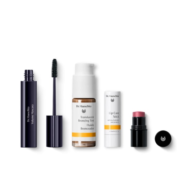 Dr. Hauschka gift set with mascara, bronzing tint, lip care stick and a pink cream stick on white background.