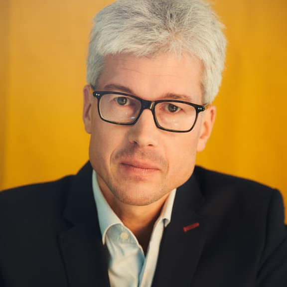 Florian Stintzing Headshot on a yellow background